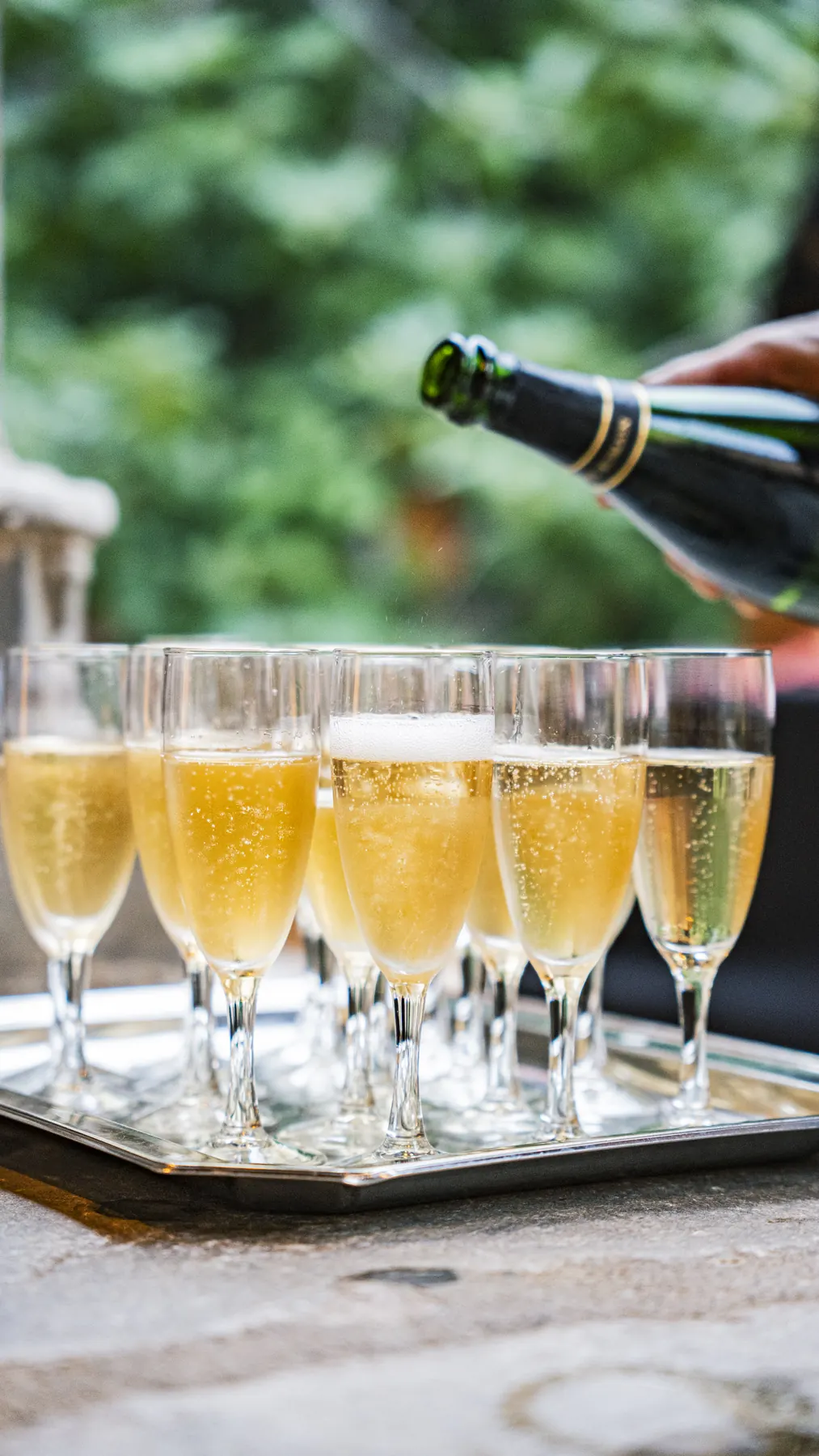 Service du champagne : coupes sur plateau d’argent dans les jardins du cloître