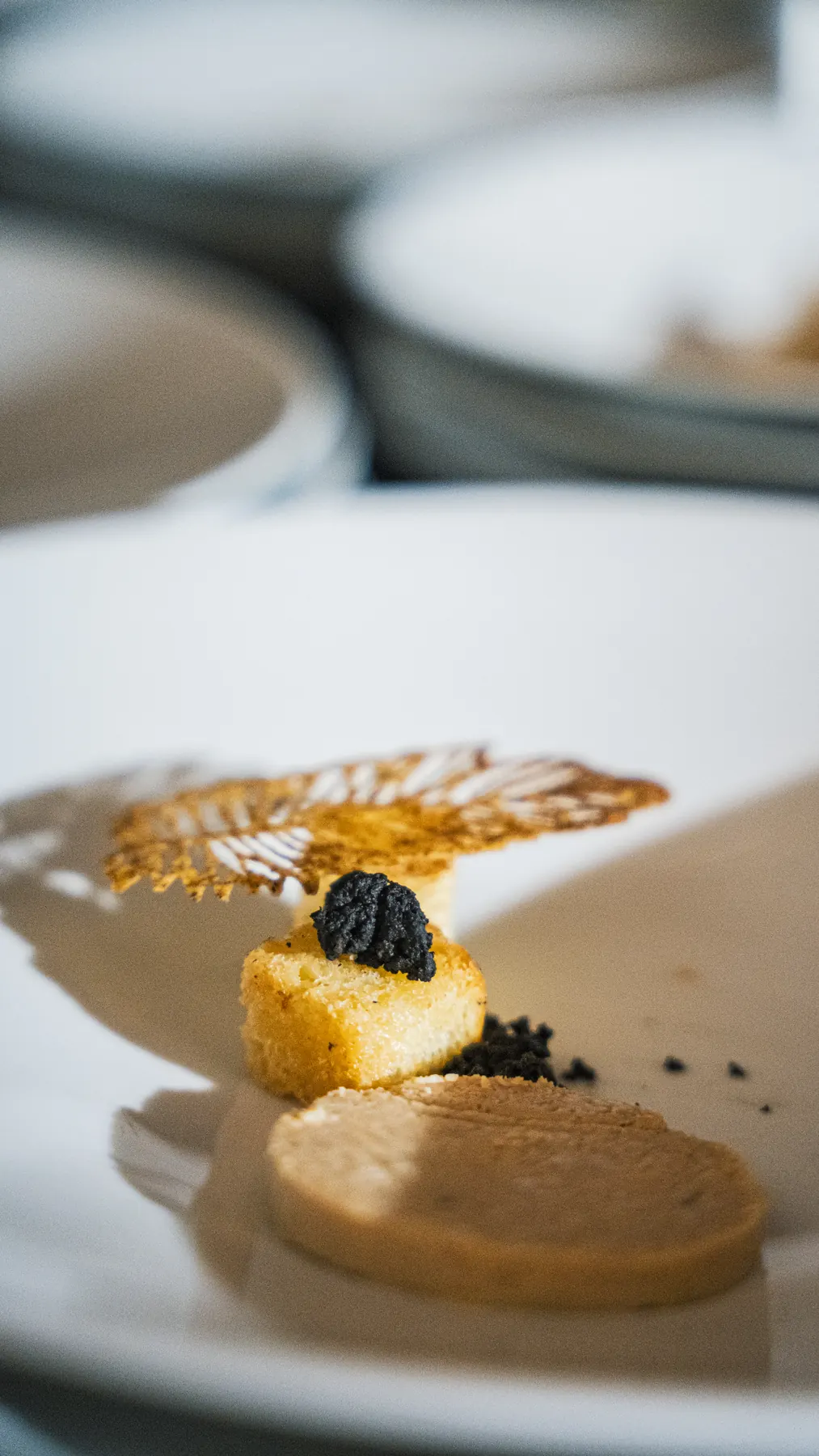 Assiette de foie gras, caviar et tuile dorée dressée par les équipes Falcou