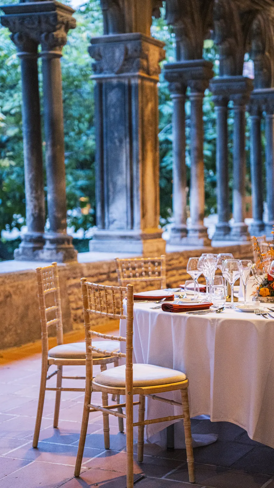 Table dressée en blanc encadrée par les colonnes du cloître des Augustins